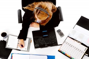 busy woman working at her desk. view from overhead of messy desk