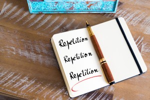 Retro effect and toned image of a fountain pen on a notebook. Handwritten text Repetition Repetition Repetition as business concept image