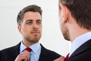 Portrait of a businessman looking at himself in the mirror